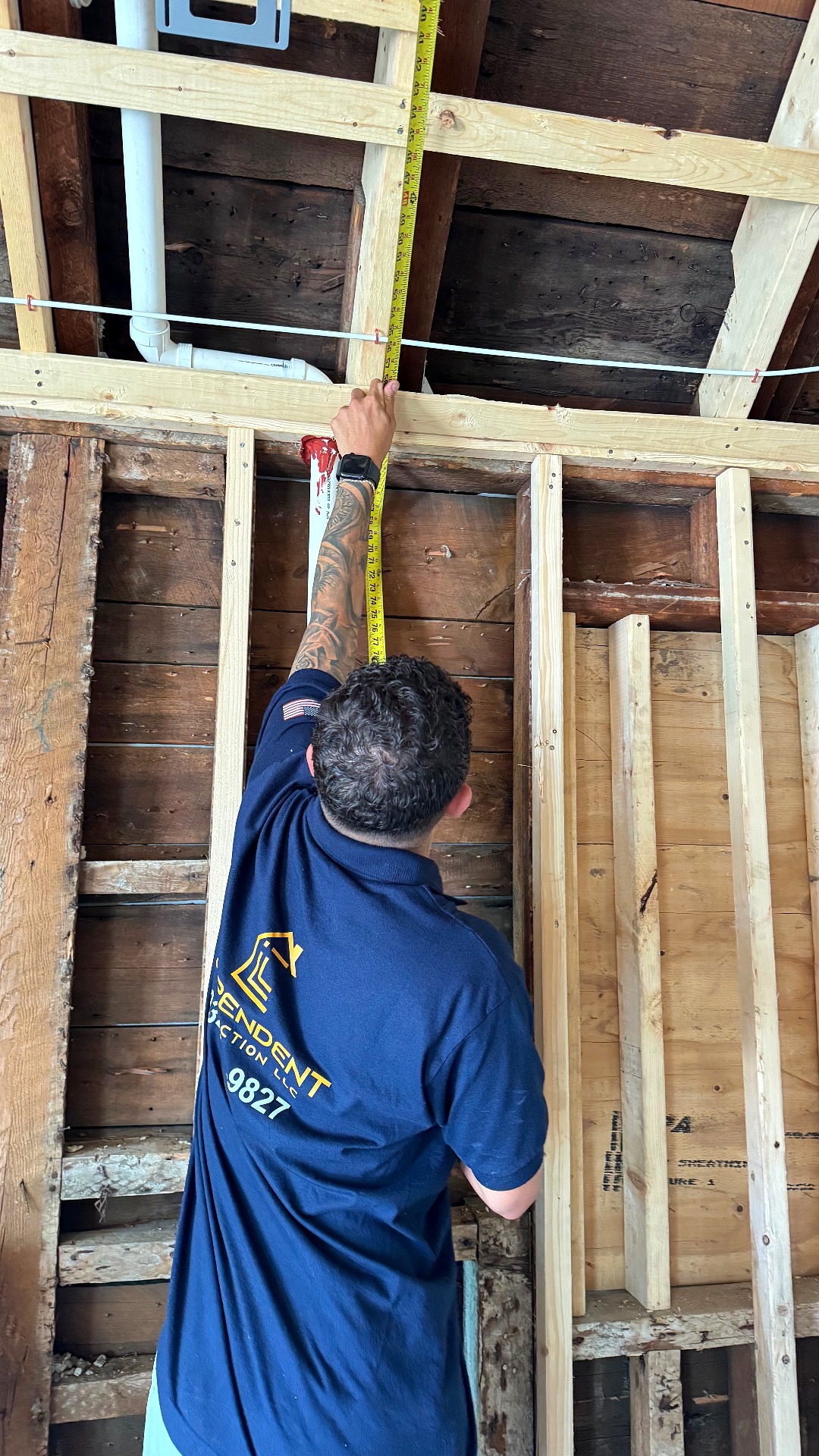 Independent Construction team member measuring wall studs during a framing job